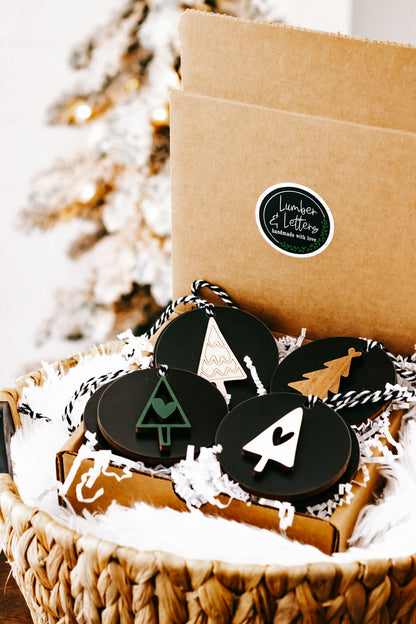 Black Christmas ornament set with tree and house shapes, twine strings, in straw basket