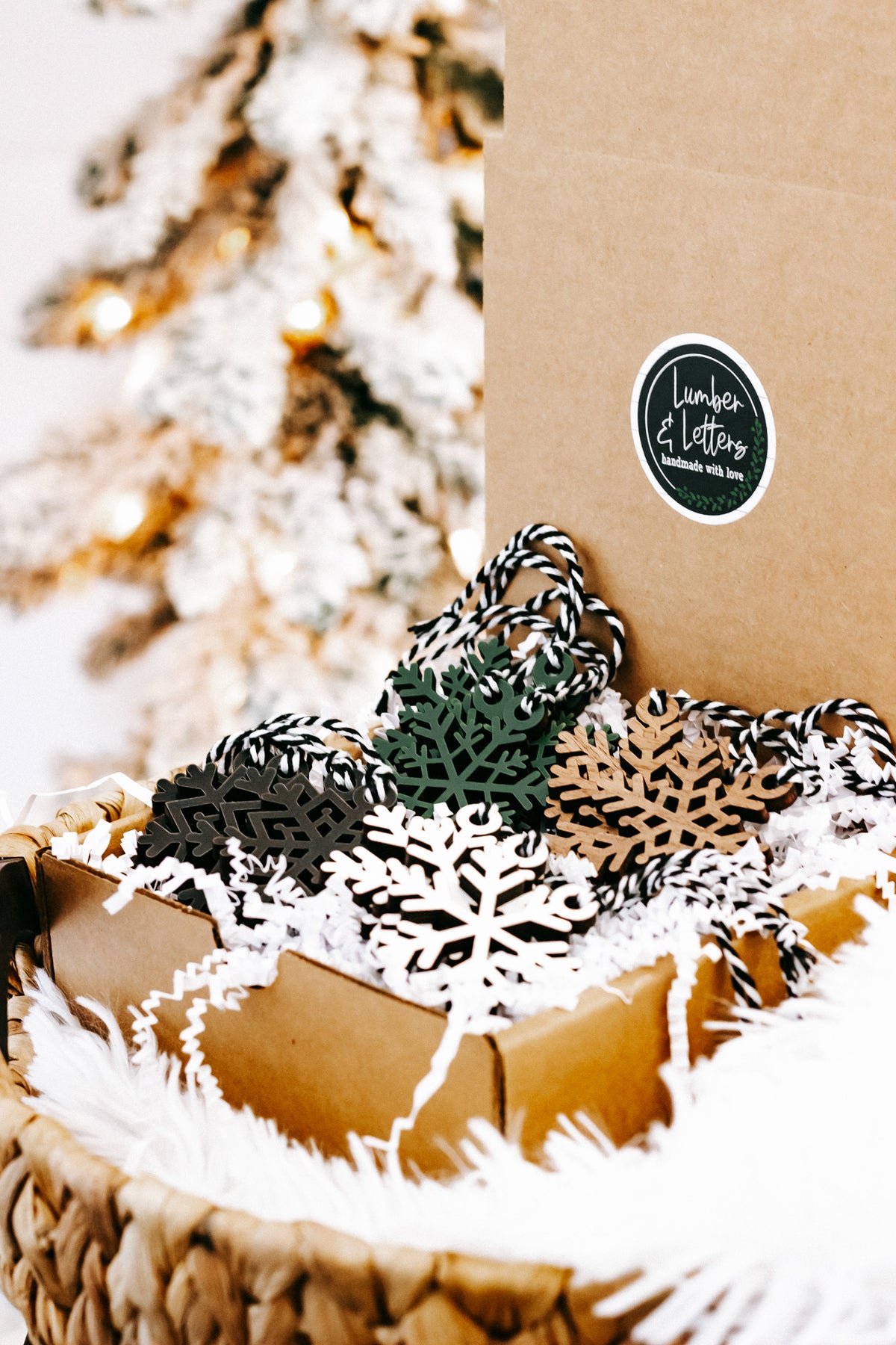 Set of snowflake Christmas tree ornaments in black, white, green, and tan with string loops