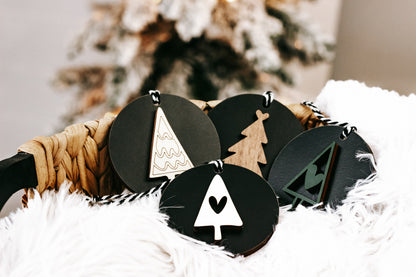Set of black Christmas ornament discs with white tree outline and hanging loops