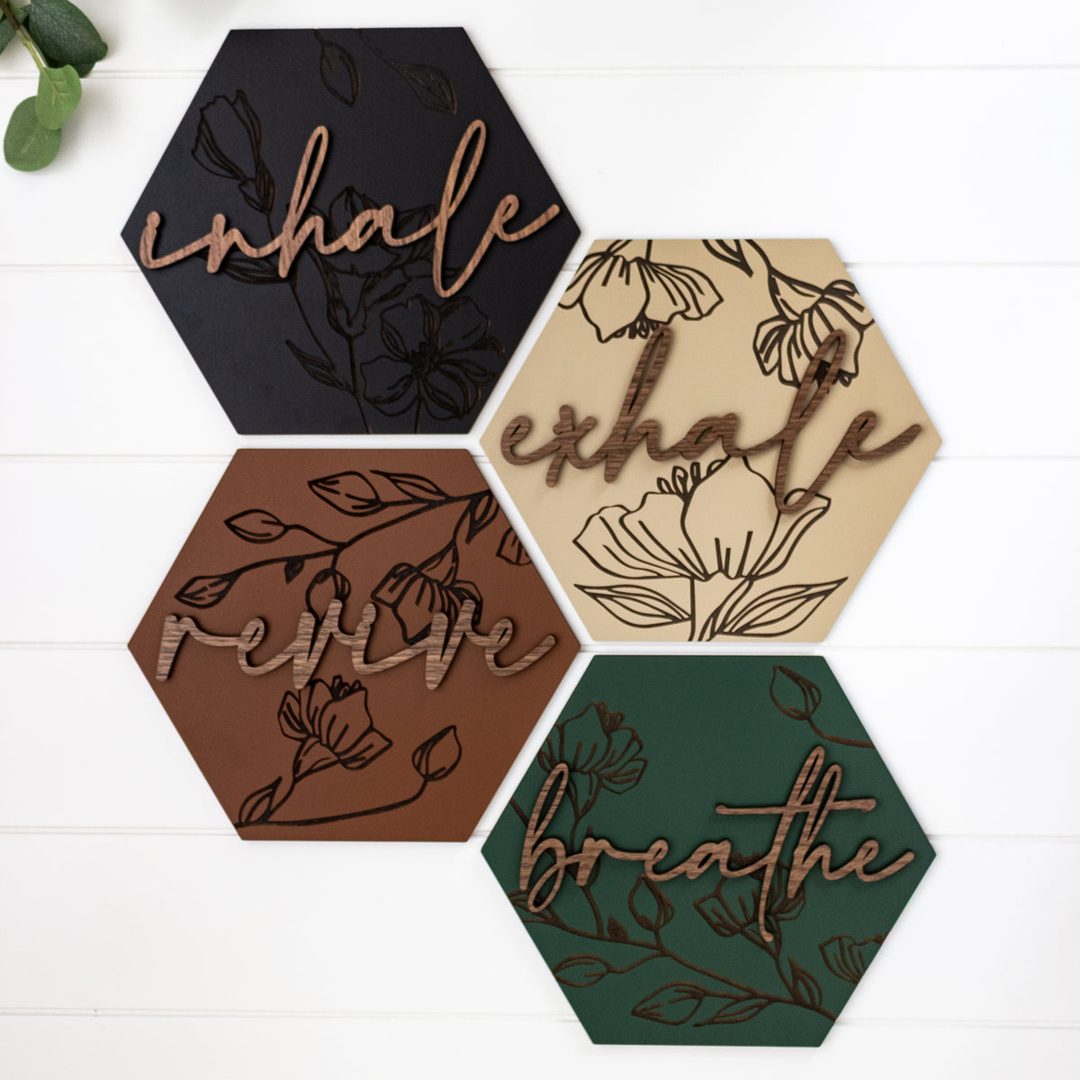 Five hexagon wooden wall art pieces with engraved floral designs and embossed script