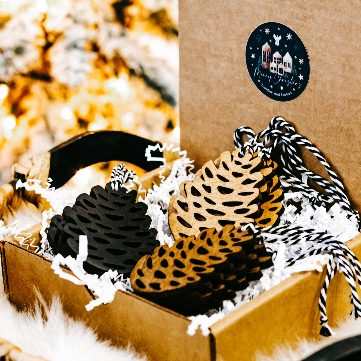 Hand-stained wooden pinecone ornaments in black, amber, and natural wood tones with twine