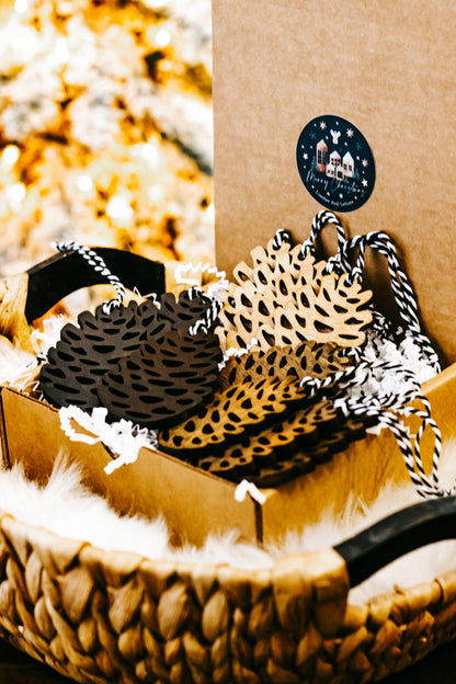 Hand-stained wooden pinecone ornaments, black and tan speckled forms on display tray