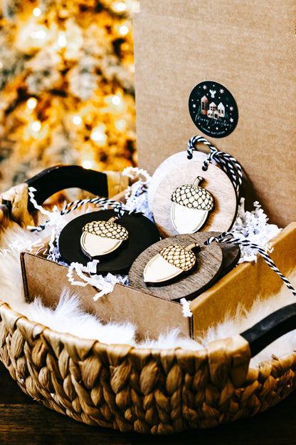 Basket display of round acorn ornaments with gold checkered caps and striped twine hangers.