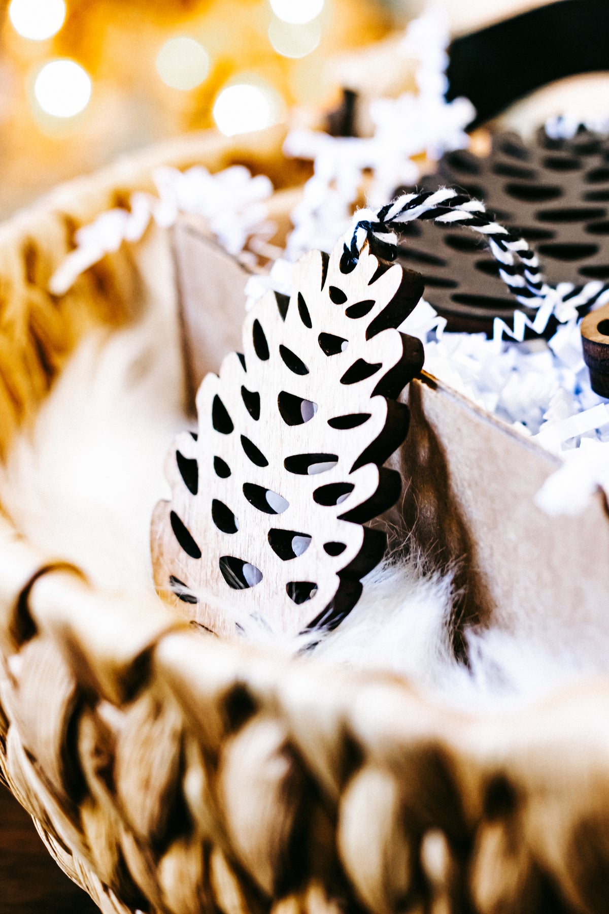 Close-up of a hand-stained wooden pinecone ornament with striped twine hanger
