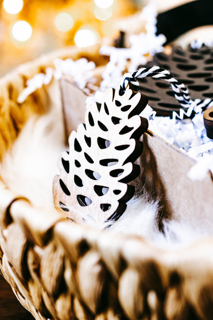 Close-up of a hand-stained wooden pinecone ornament with striped twine hanger