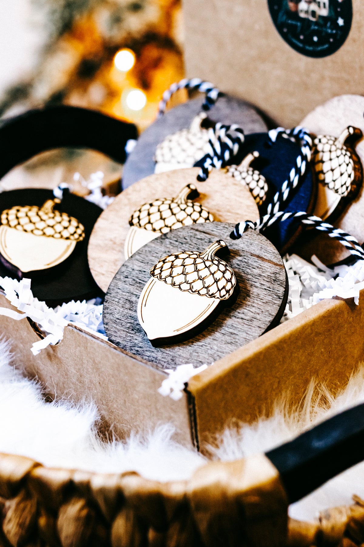 Close-up of round acorn ornaments with checkered gold caps on twine, in assorted wood and black.