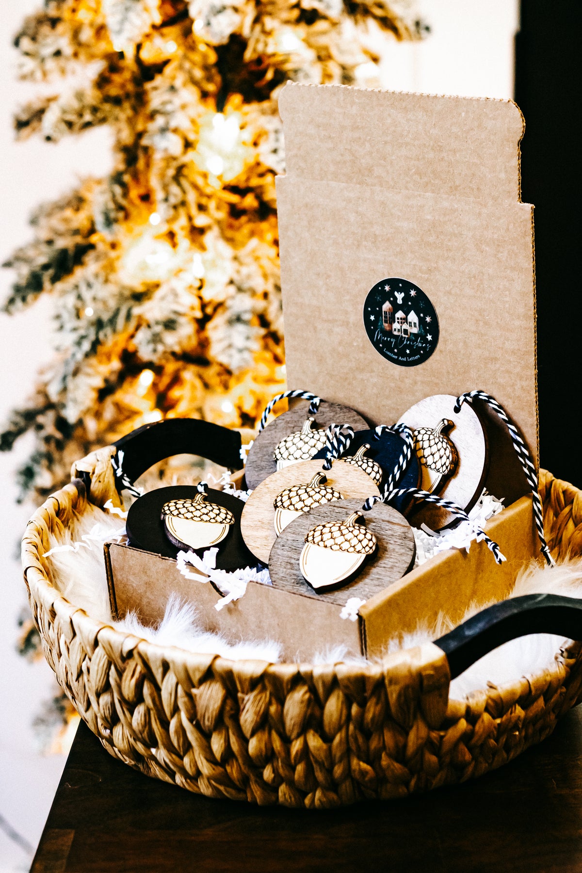 Round acorn ornaments in a basket with twine loops and gold checkered tops on wood and black.