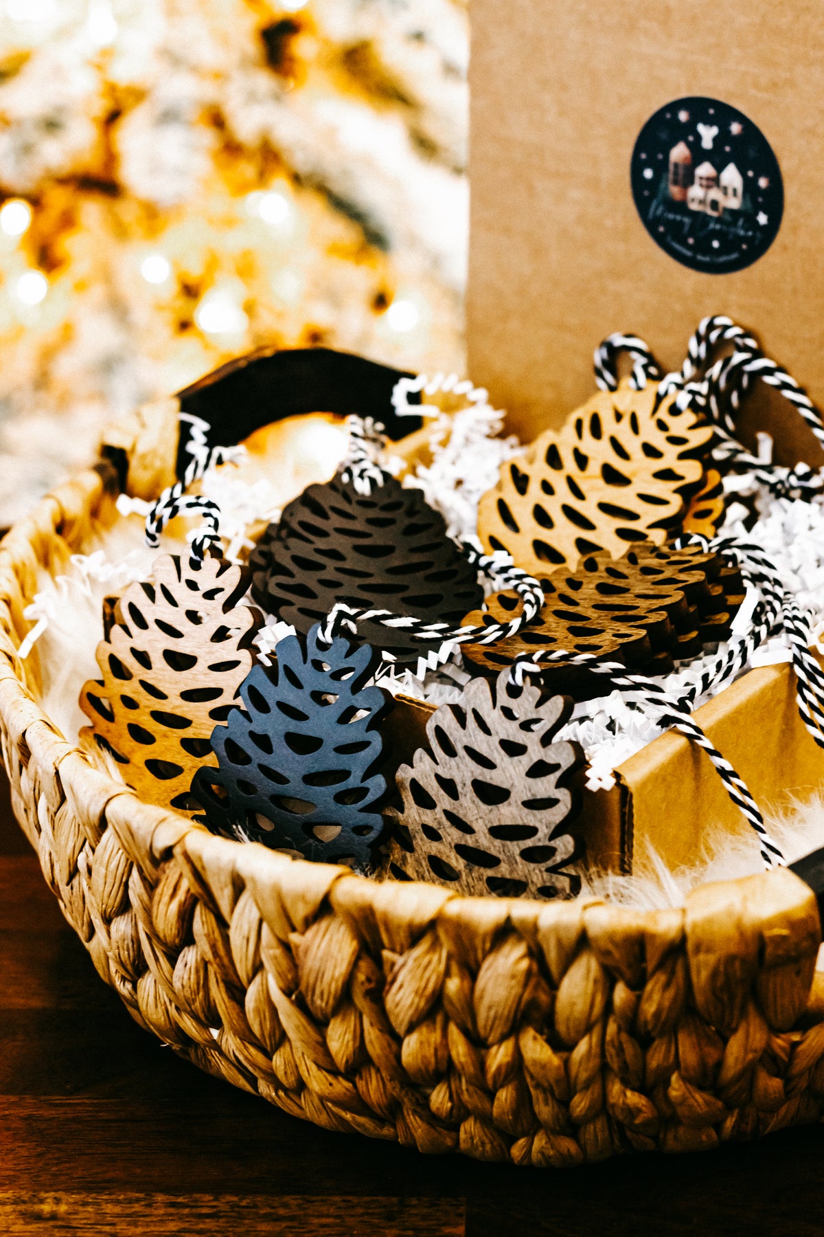 Wooden pinecone ornaments with striped twine hangers arranged in a woven basket