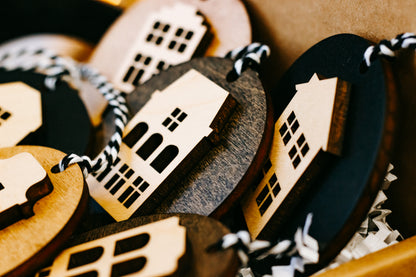 Close-up of round house ornaments in wood and dark finishes, with striped hanging cords