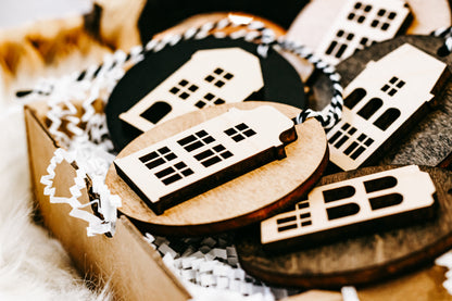 Stack of round house ornaments showing window cutouts on wood and dark disc layers
