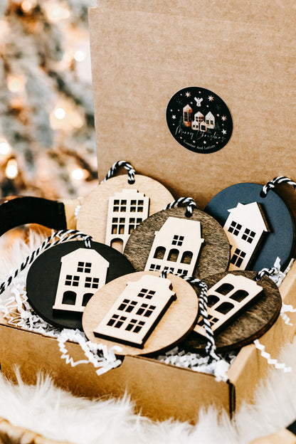 Round house ornaments in a kraft box with white filler and hanging striped cords