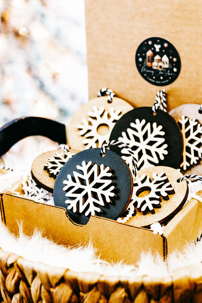 Layered snowflake ornaments in crate, black and light wood discs with white cutouts