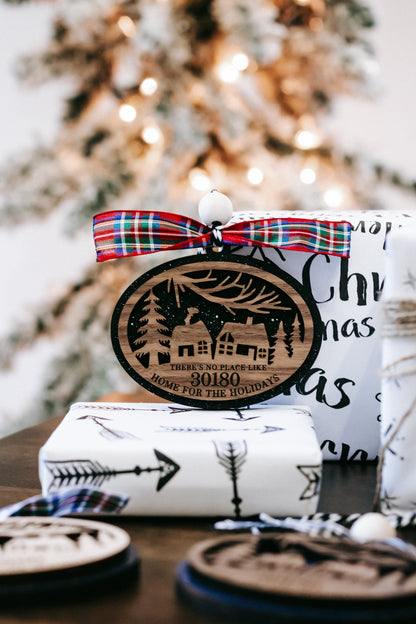 Round Christmas ornament with 30180 zip code and red-blue plaid bow over wrapped gift