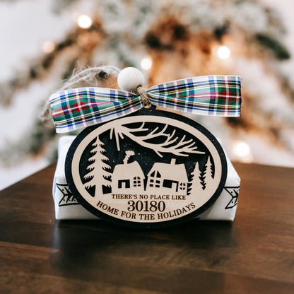 Round Christmas ornament with 30180 zip code, house-and-trees artwork, and plaid bow