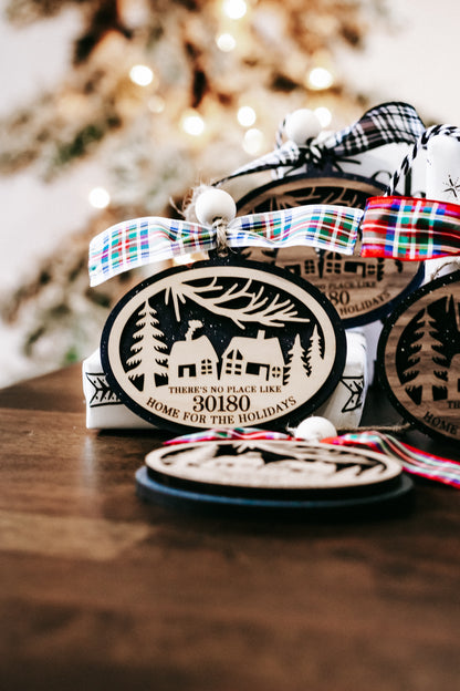 Hanging Christmas ornament with plaid bow, house scene, and zip code 30180, close view.