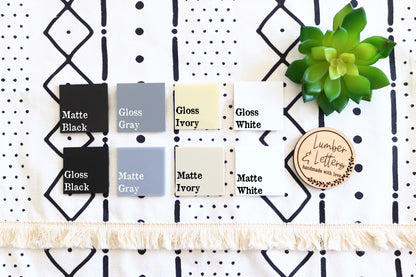 Restroom sign finish swatches: matte and gloss options labeled in black, gray, ivory, and white
