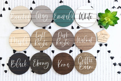 Round finish samples for restroom signs in multiple colors, displayed on a patterned board