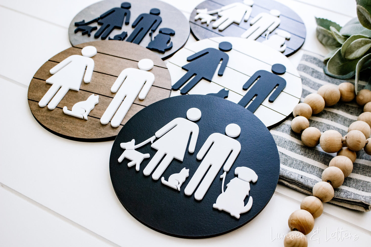 Round restroom sign with pet silhouettes on dark blue and tan cork-style backgrounds