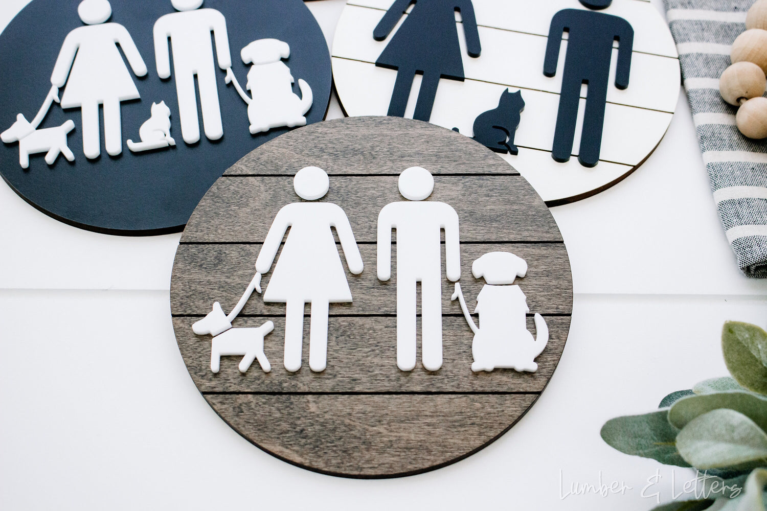 Round restroom sign with pet silhouettes in gray-blue and tan with white icons