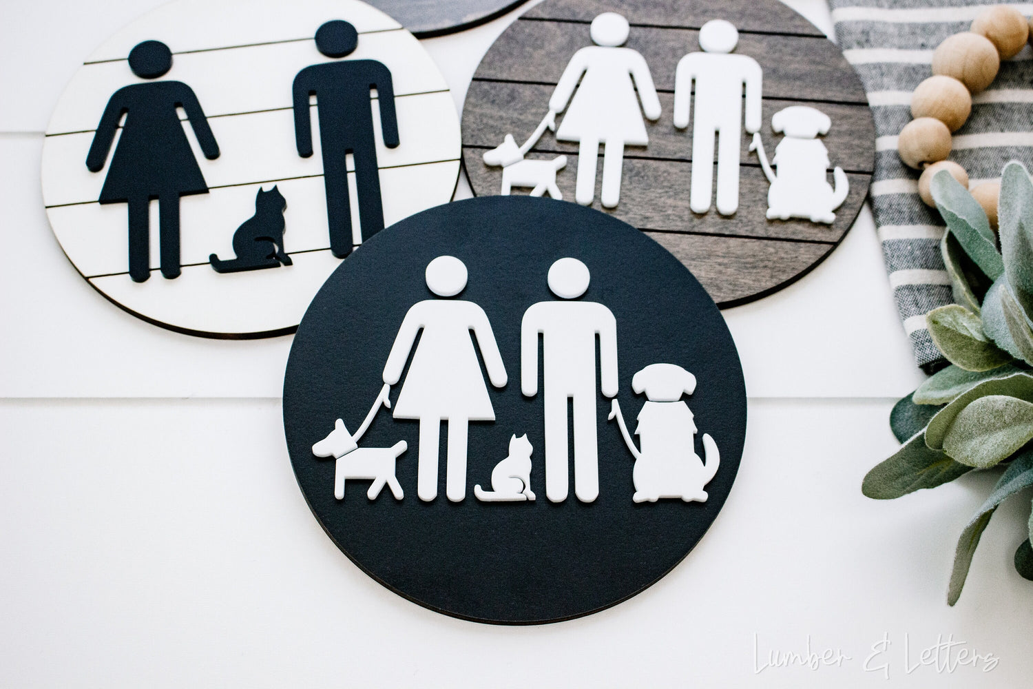 Two round restroom signs with pet silhouettes: dark navy and tan icons with white circles